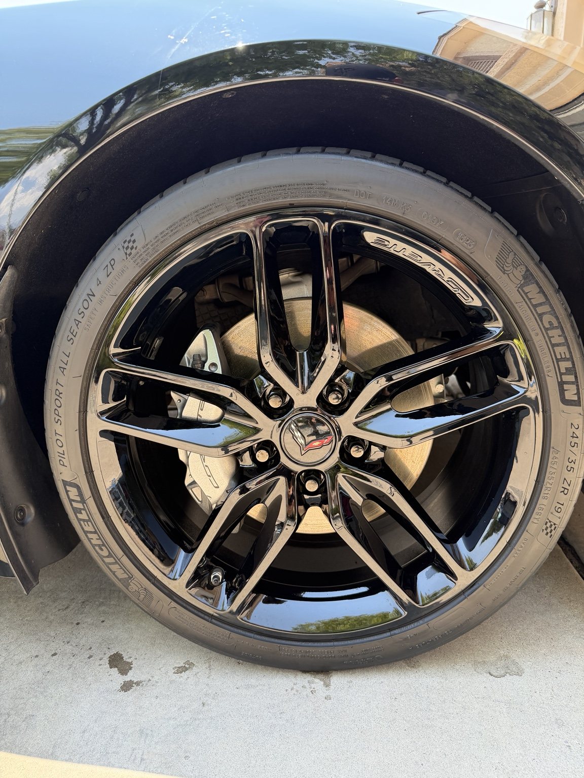 Clean Corvette wheel with glossy black spokes, center cap, and dressed tire